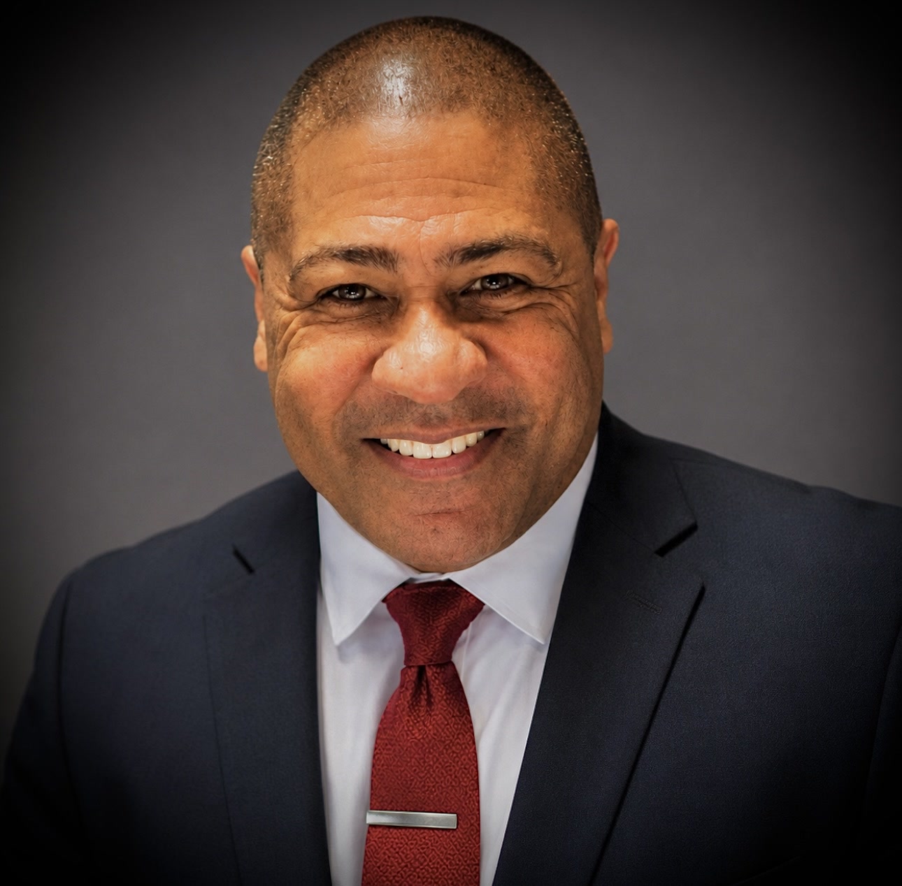 Kevin Lewis, founder of Mr. Finnster Unleashed, in a dark suit and burgundy tie