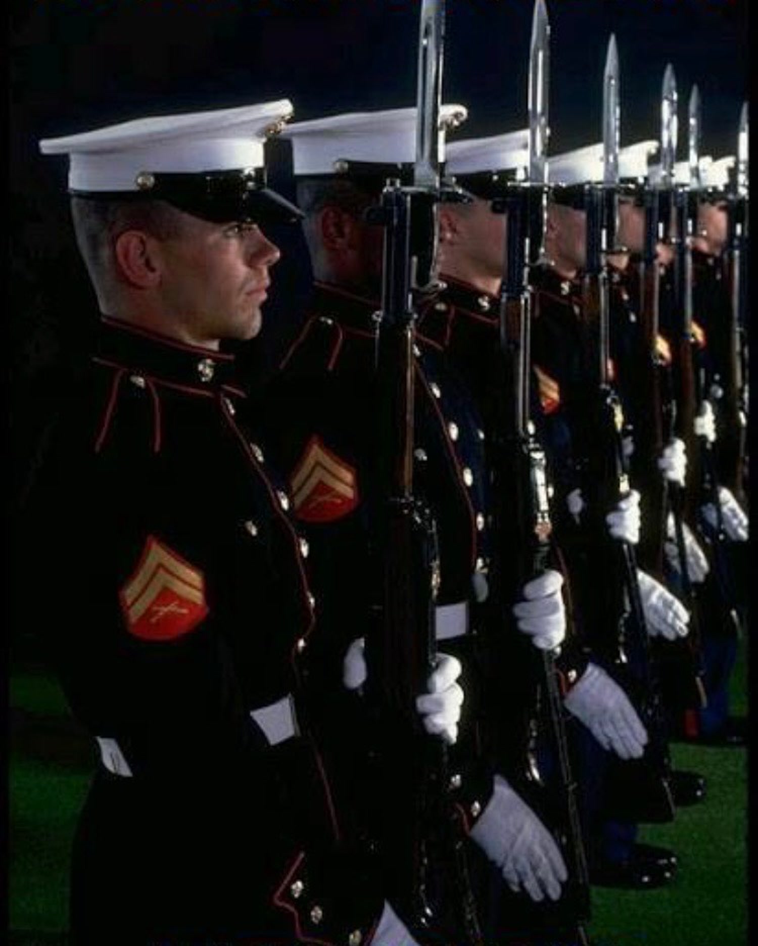 Marines standing at attention in dress blues during a ceremony